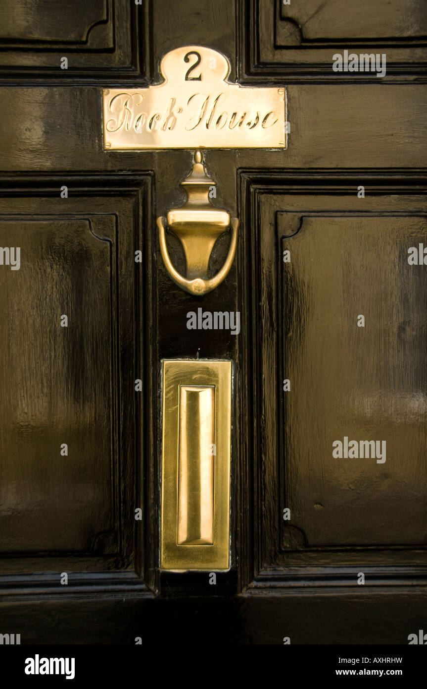 2 Rock House ; ottone lucidato respingente porta piastra nome e letterbox su verniciato di colore nero porta di legno Tenby Pembrokeshire Wales UK Foto Stock