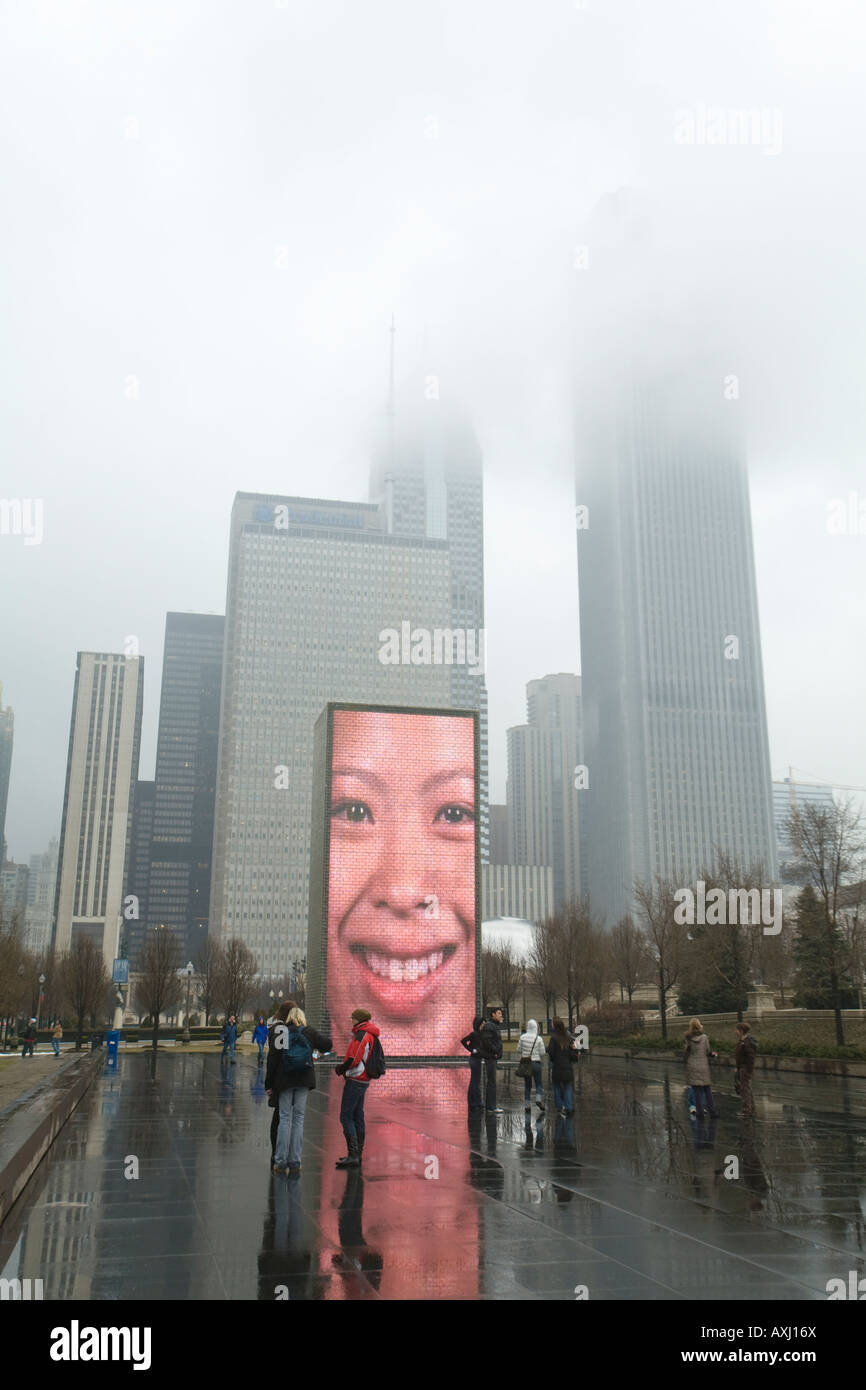 ILLINOIS Chicago Crown Fontana nel Millennium Park di nebbia e Rainy day volto riflesso sullo schermo i visitatori scattano fotografie Foto Stock