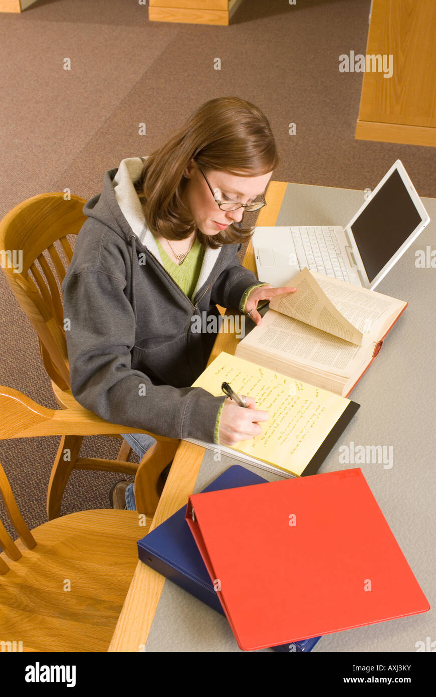 Una giovane donna studi nella libreria Foto Stock