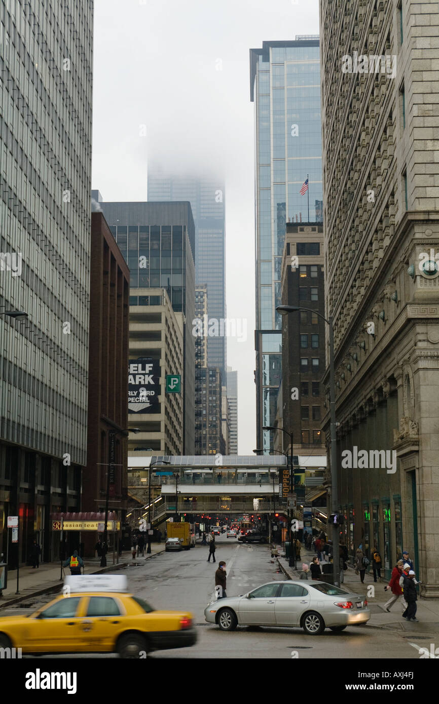 ILLINOIS Chicago treno El e taxi sulla strada nuvoloso e nebbioso giorno Sears Tower nascosti in basso le nuvole Foto Stock