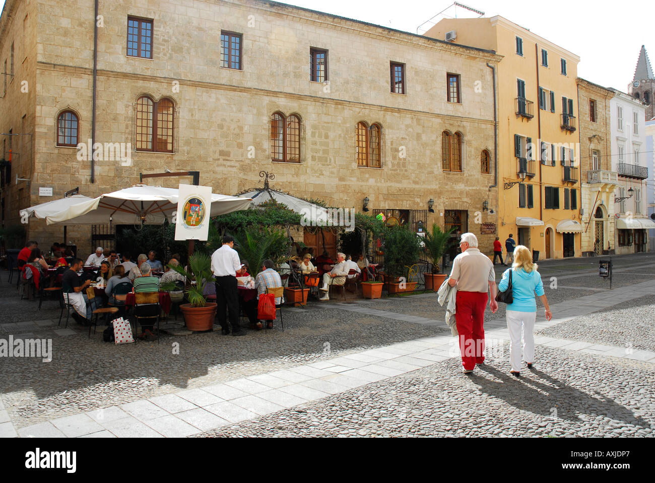 Coppia di anziani approccio ristorante Alghero in tarda serata sun Foto Stock