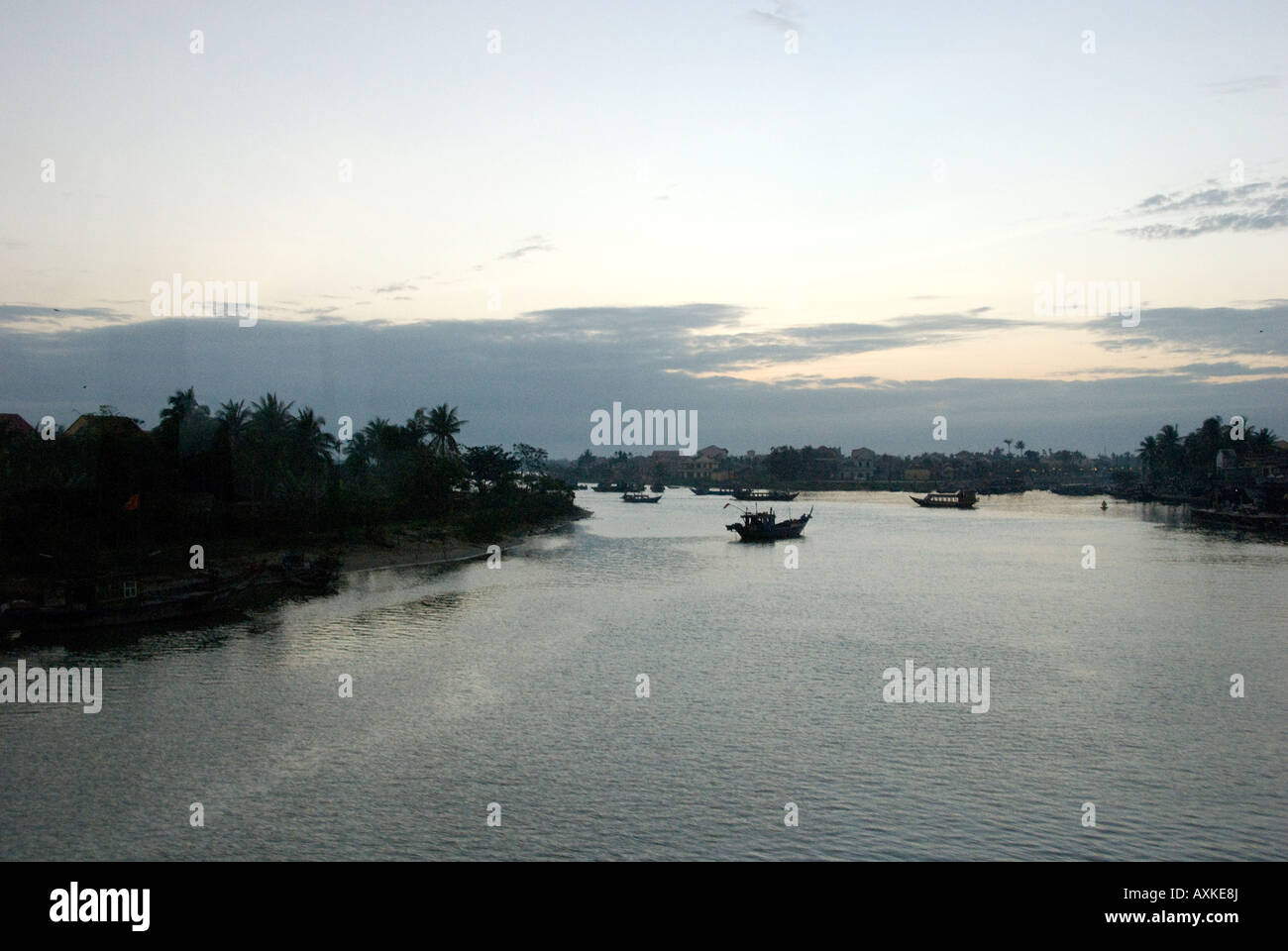 Tramonto sul viale alberato di Thu Bon River Hoi An Vietnam con barche mid-stream Foto Stock