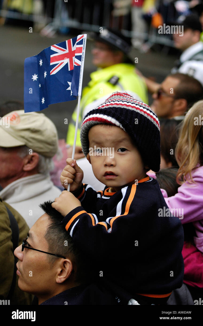 Un Cinese Australian bambino sventola una bandiera australiana durante l'Anzac Day parade di Sydney. Foto Stock