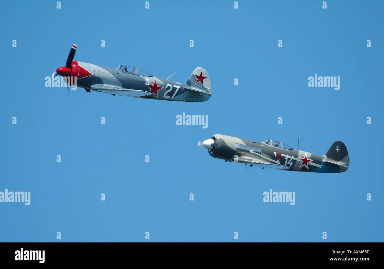 Due vecchi aerei Russi in volo di formazione: sinistra Yak 3U e diritto Yak11, francese vintage air show, La Ferte Alais, Francia Foto Stock