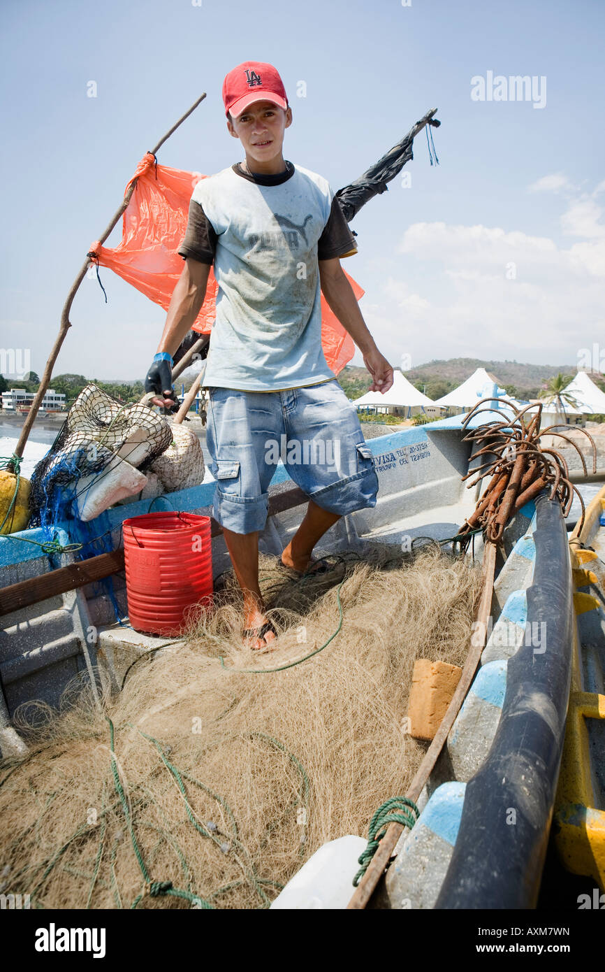 Ragazzo riassettavano le reti villaggio di pescatori di La Libertad sulla costa del Pacifico in El Salvador Foto Stock