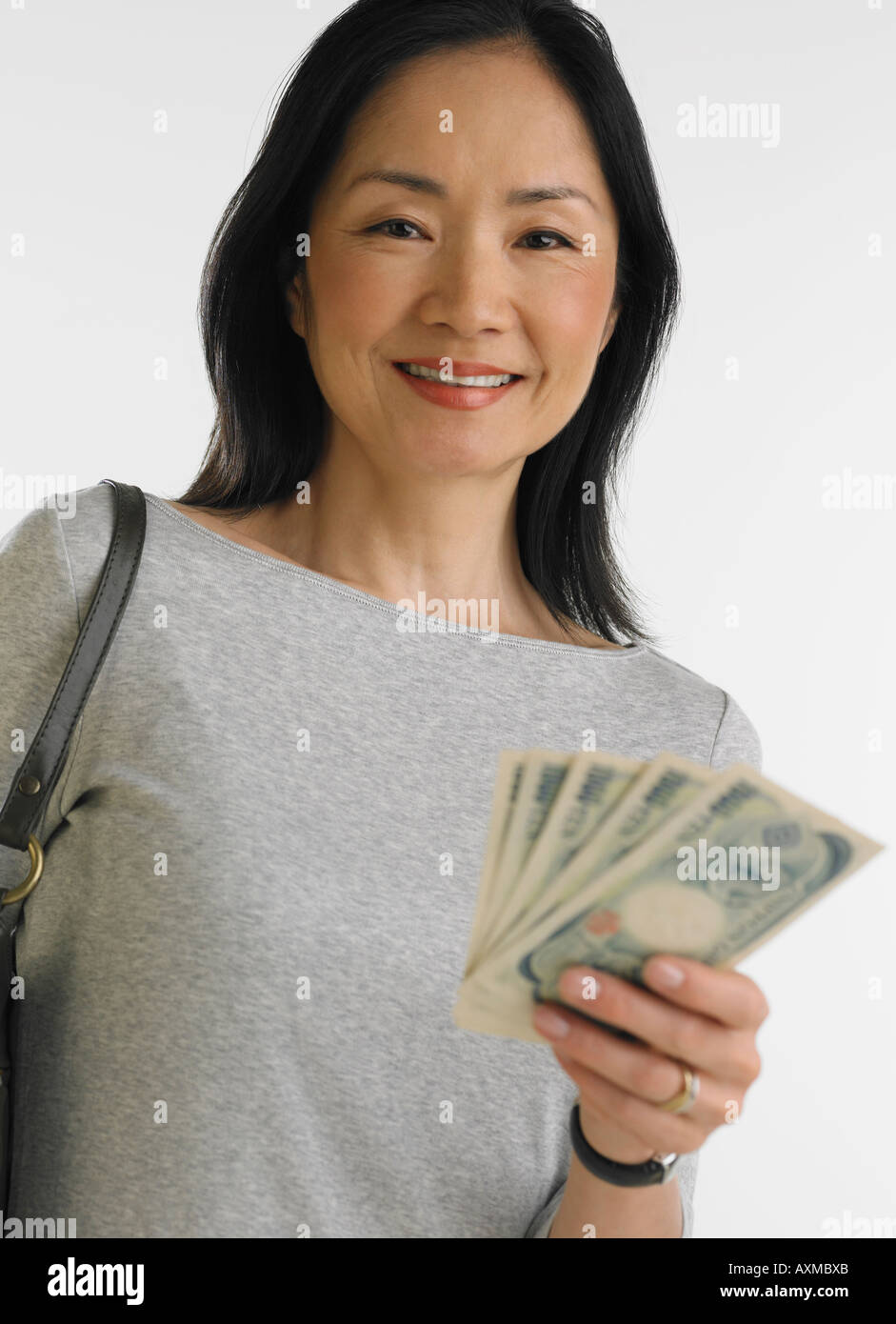 Studio shot di donna asiatica tenendo la carta moneta Foto Stock