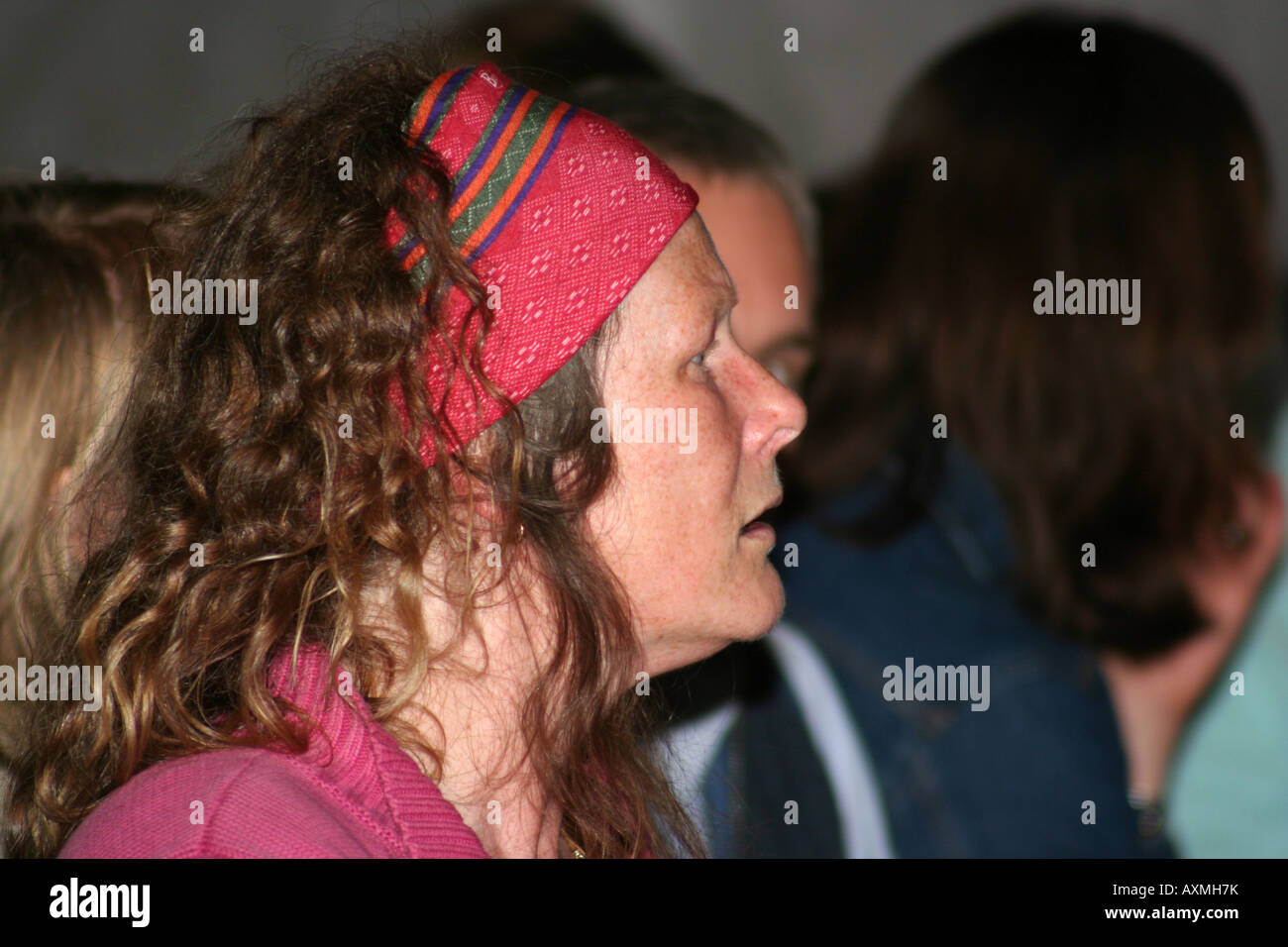 Donna con capelli rossi e red head band sembra intensamente Foto Stock