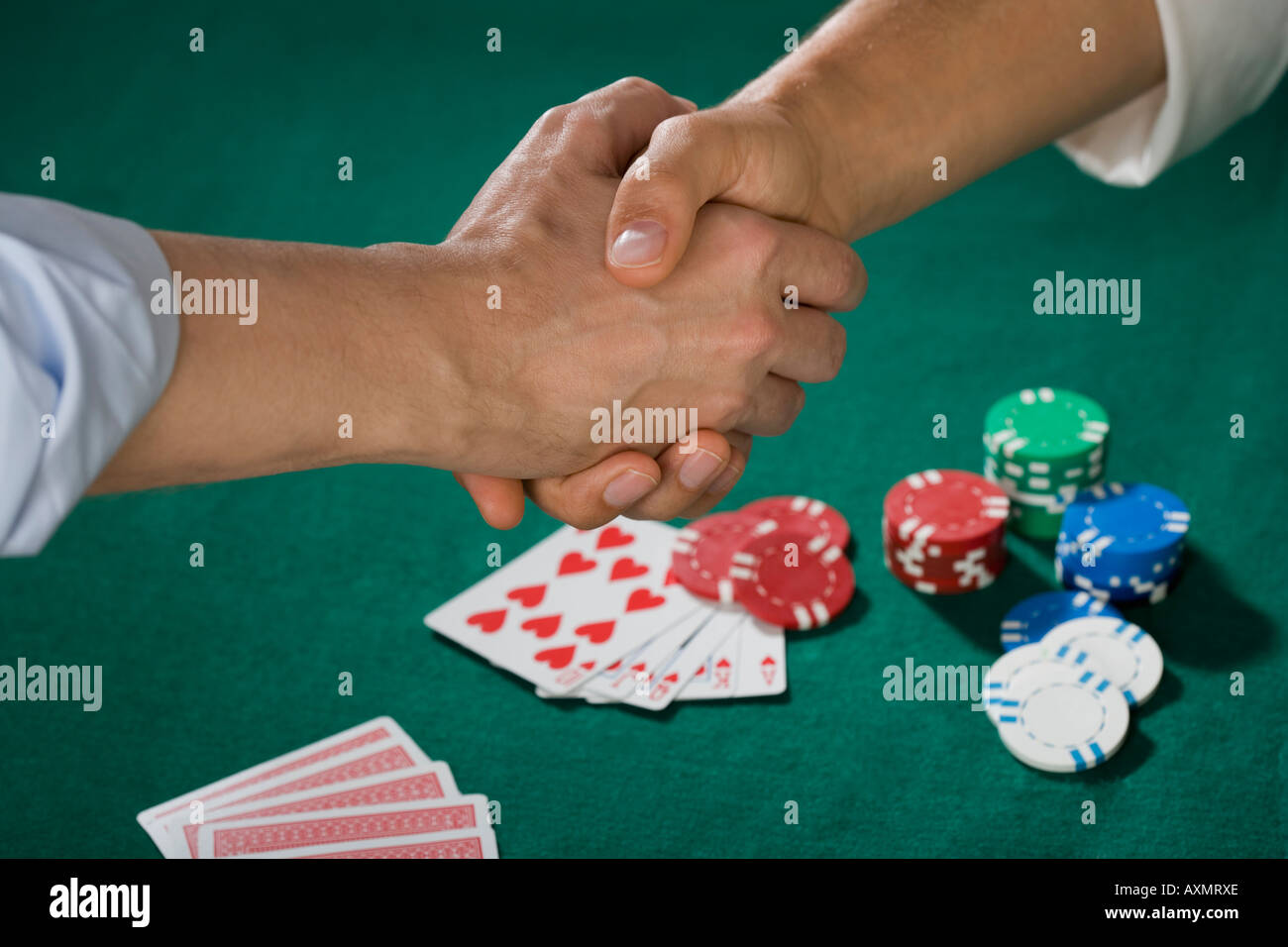 Due uomini stringono le mani su gioco del poker Foto Stock
