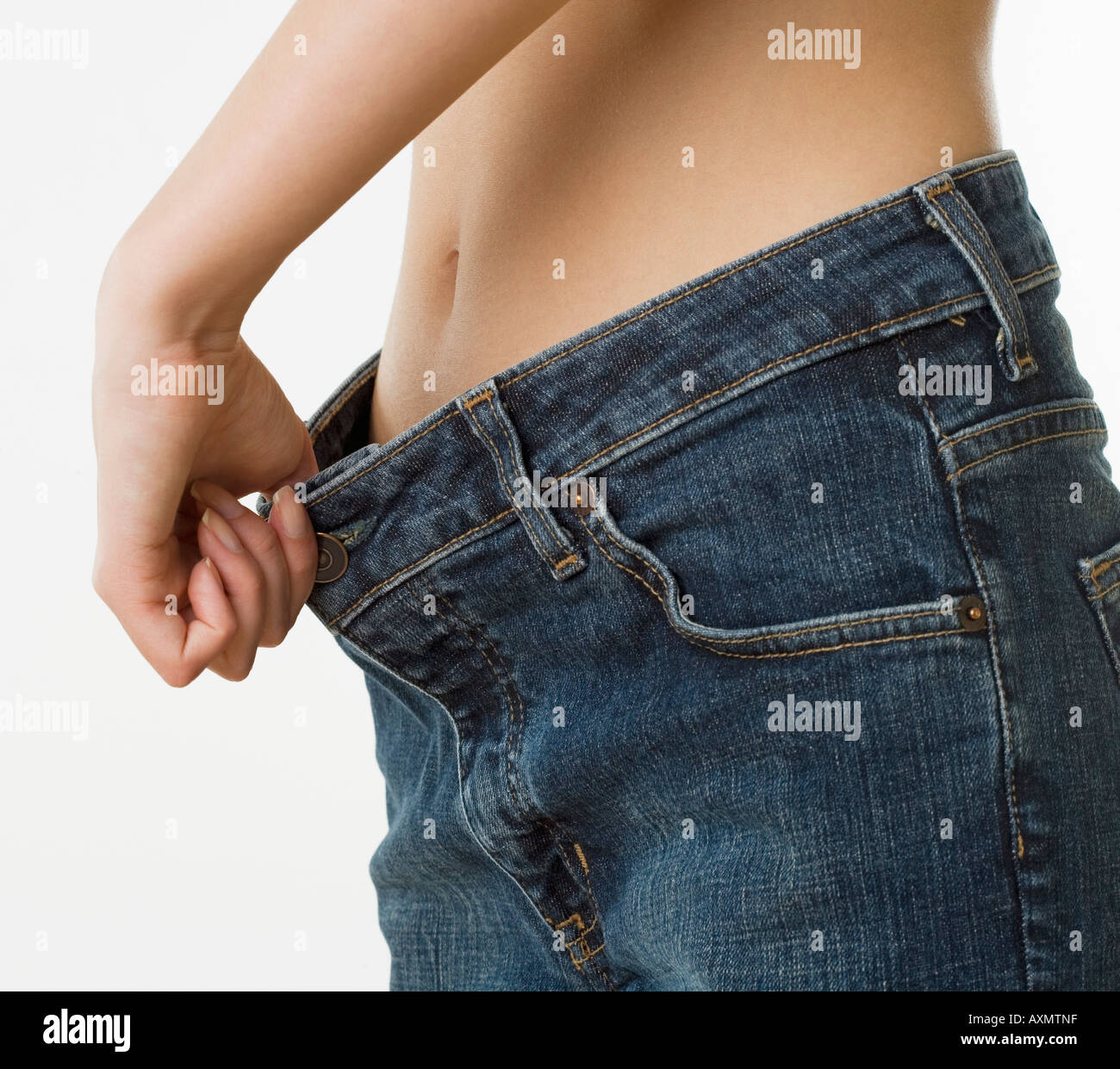 Close up della donna che mantiene la cintura dei pantaloni in allontanamento dallo stomaco Foto Stock