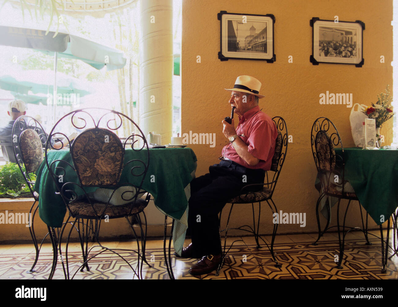 San José di Costa Rica- America centrale. L'uomo fumare la pipa nel patio del Grand Hotel Costa Rica Foto Stock