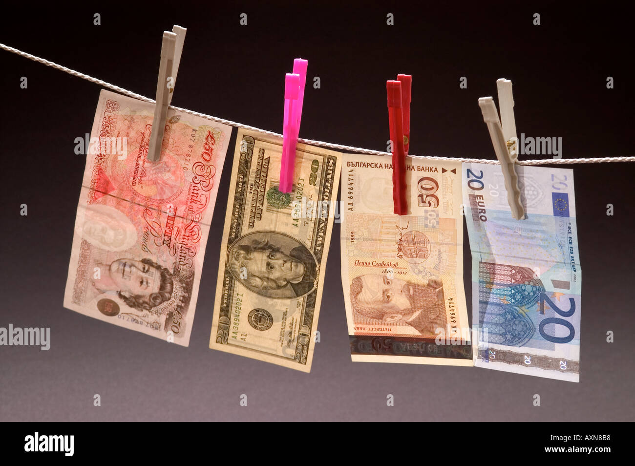 Lavate i soldi impiccato su una corda pioli valuta Dollari Sterline euro lev nota il denaro sporco essiccamento Foto Stock