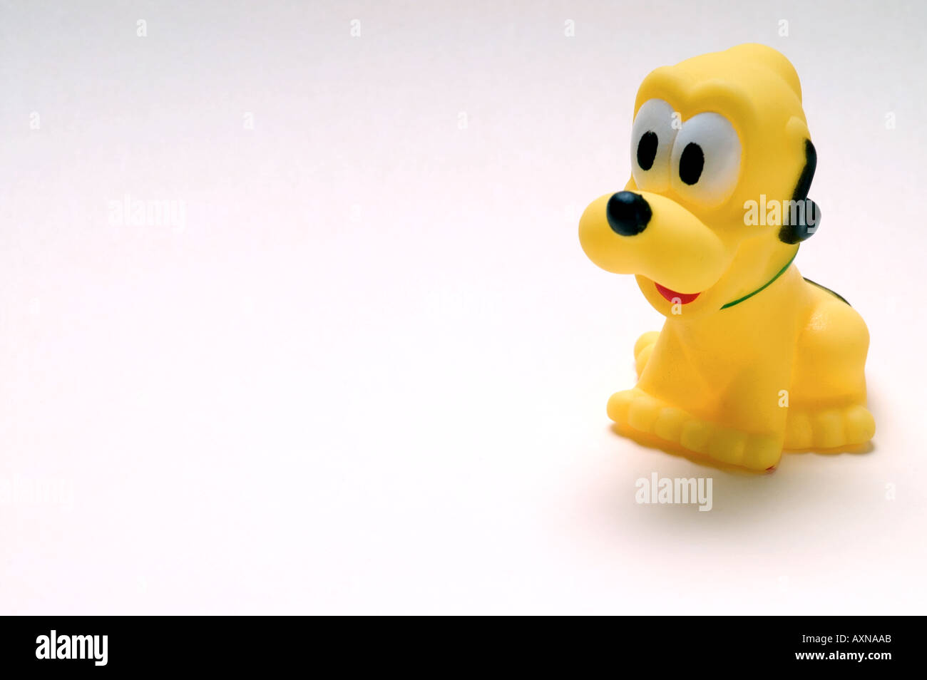 Giocattolo di gomma yellow dog figura animale simbolo di bambola infanzia singolo gioco baby cat tagliare ritagliato sullo sfondo bianco contorno tagliato Foto Stock