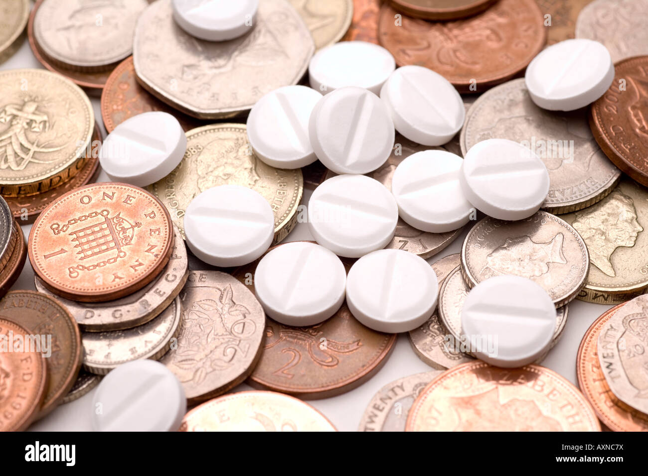 I costi di medicina industria farmaceutica di fare soldi pillole e monete sterline e pence Foto Stock