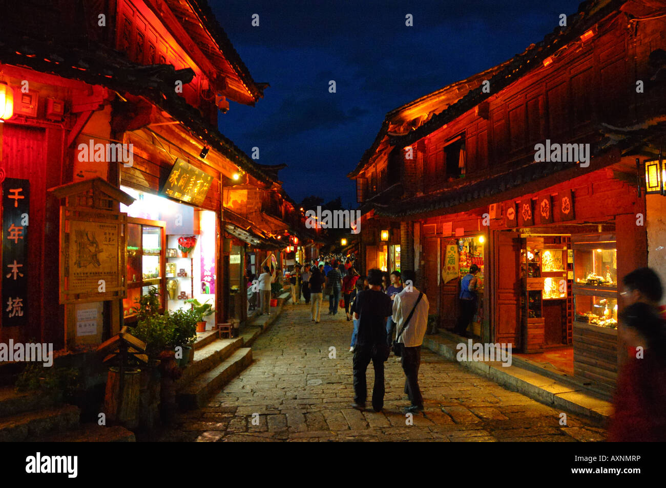 Lijiang di notte. Illuminata luminosamente negozi lungo il lastricato in pietra street. Lijiang, Yunnan in Cina. Foto Stock