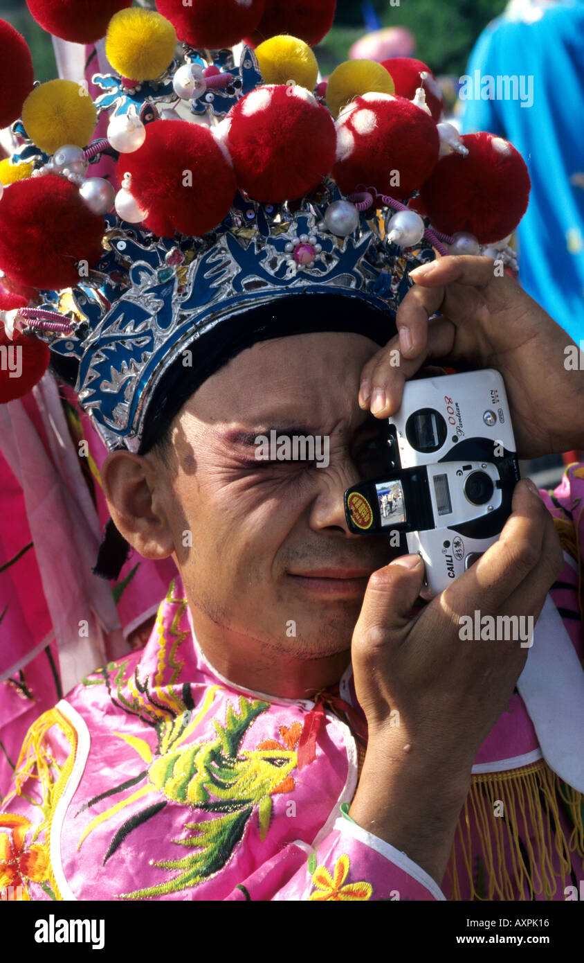 Un Cinese stilt esecutore con il tradizionale costume teatrale utilizza una telecamera. 18 Set 2005 Foto Stock