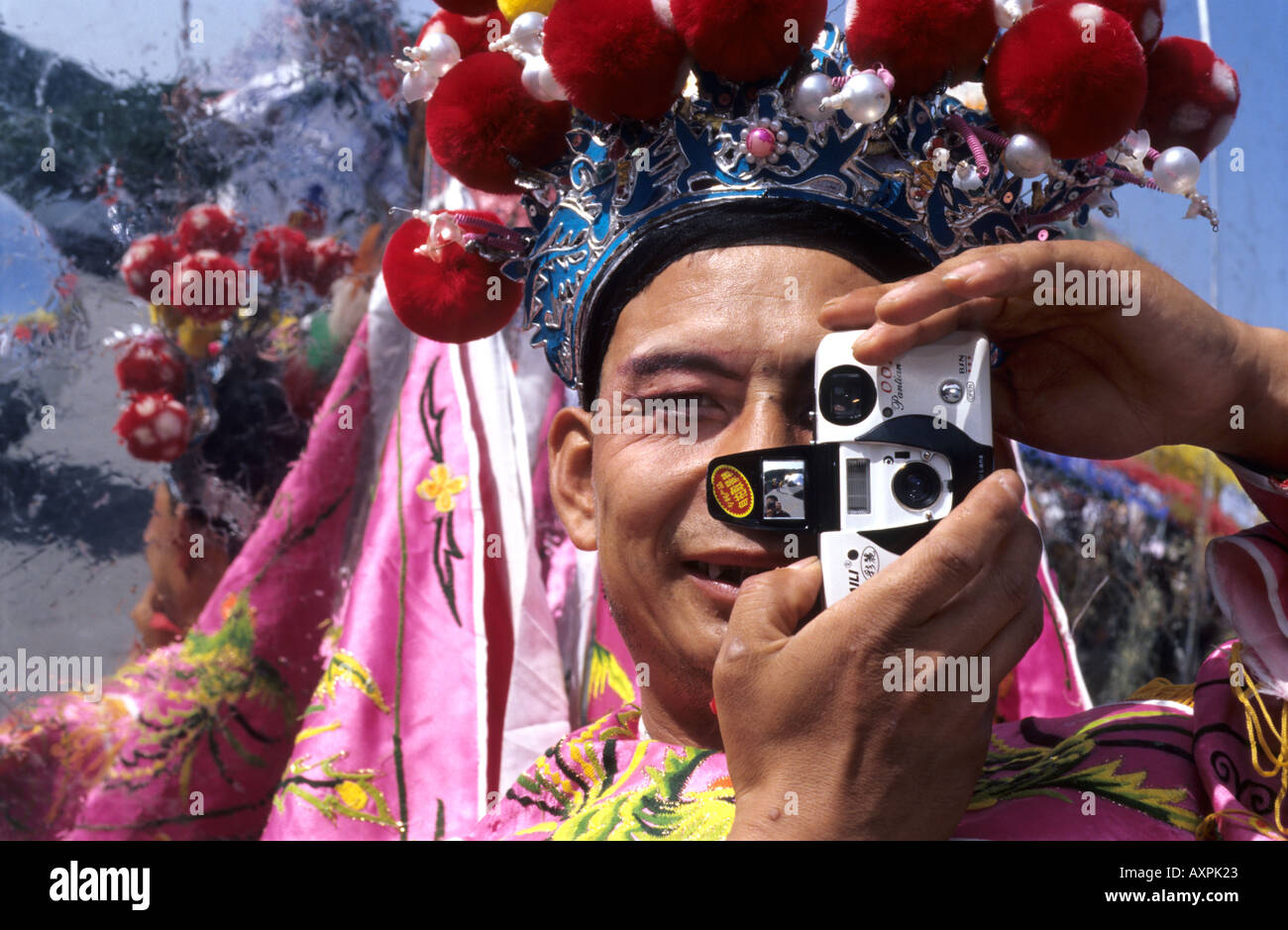 Un Cinese stilt esecutore con il tradizionale costume teatrale utilizza una telecamera. 18 Set 2005 Foto Stock