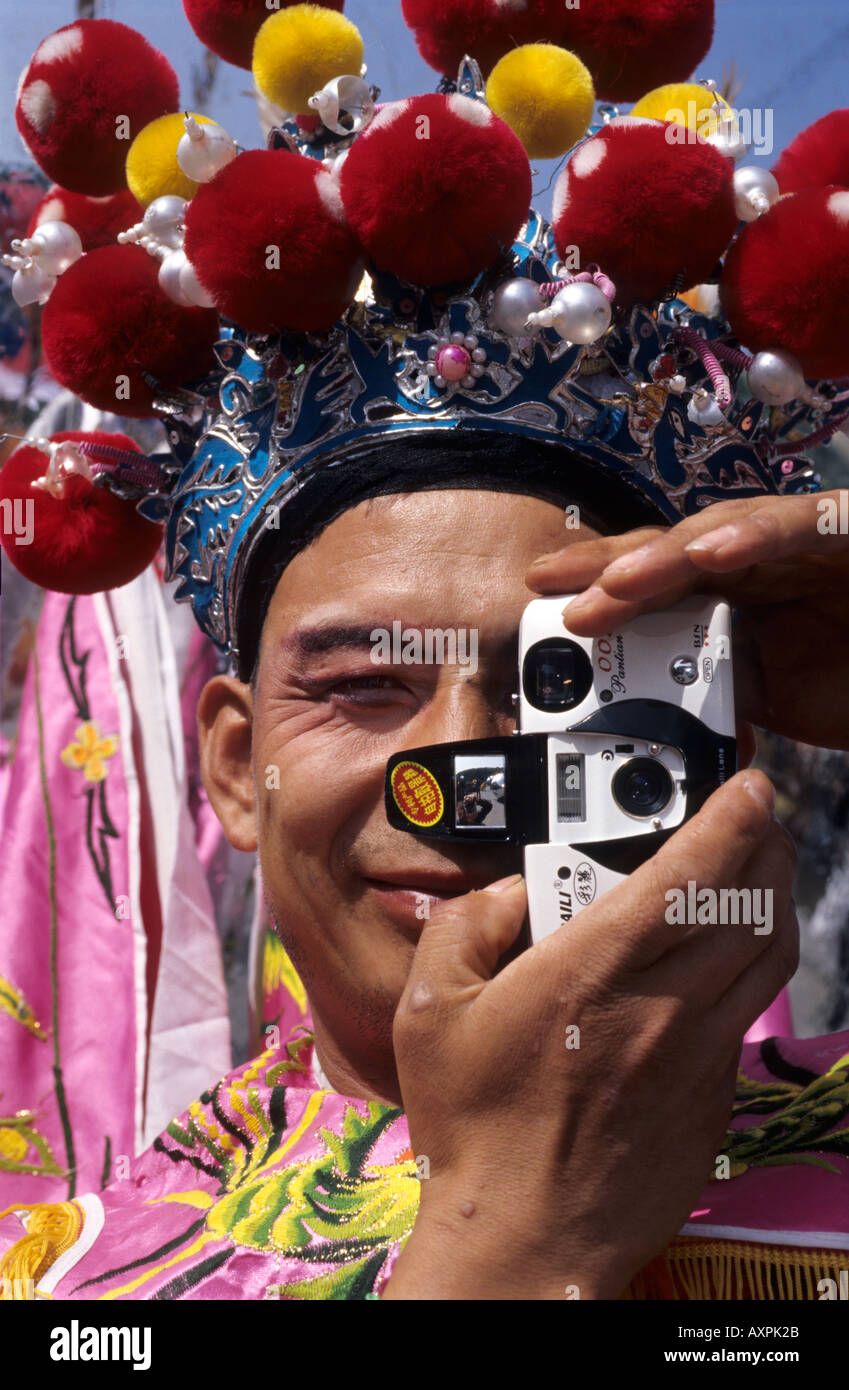 Un Cinese stilt esecutore con il tradizionale costume teatrale utilizza una telecamera. 18 Set 2005 Foto Stock