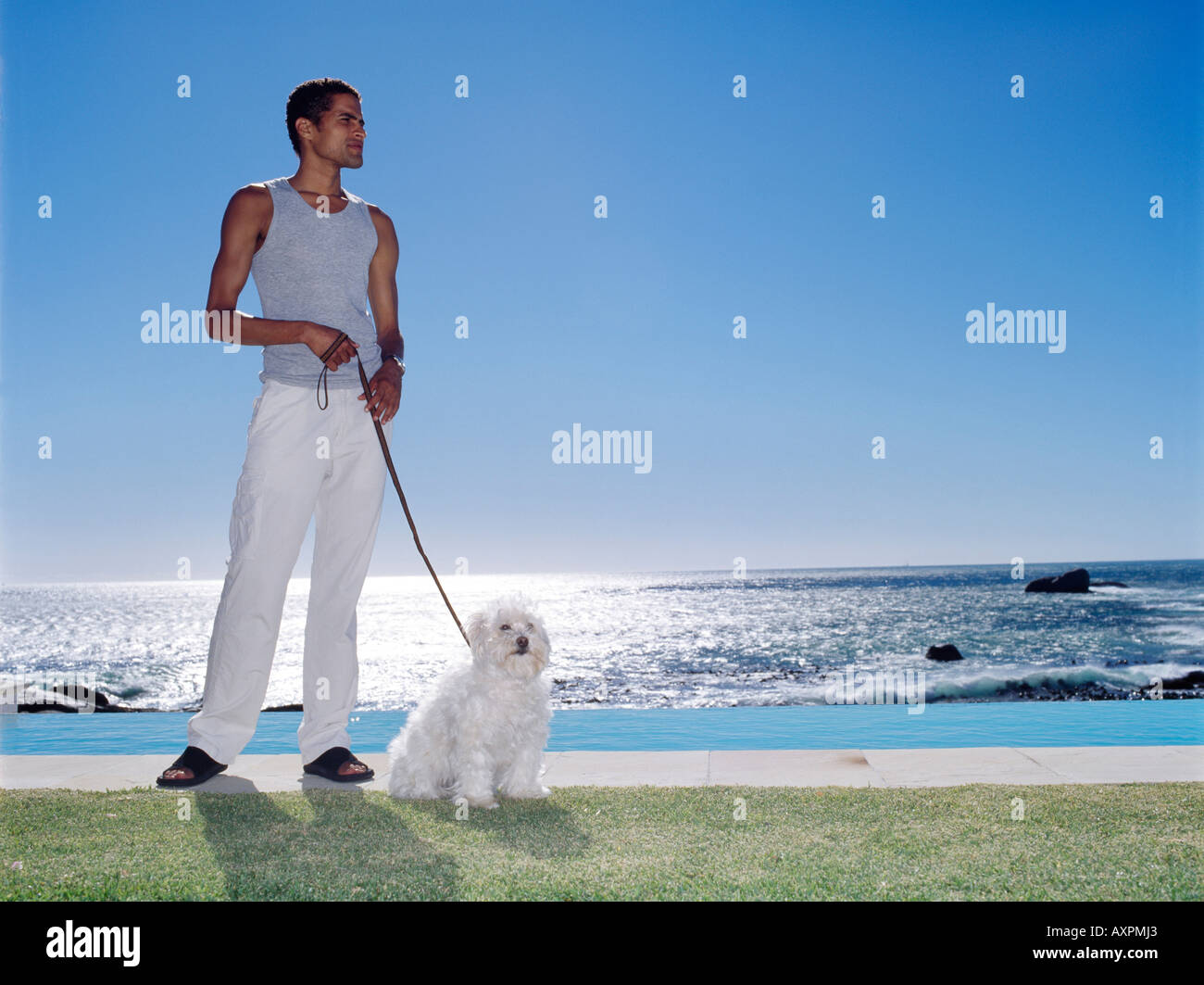 Giovane uomo in possesso di un cane al guinzaglio Foto Stock
