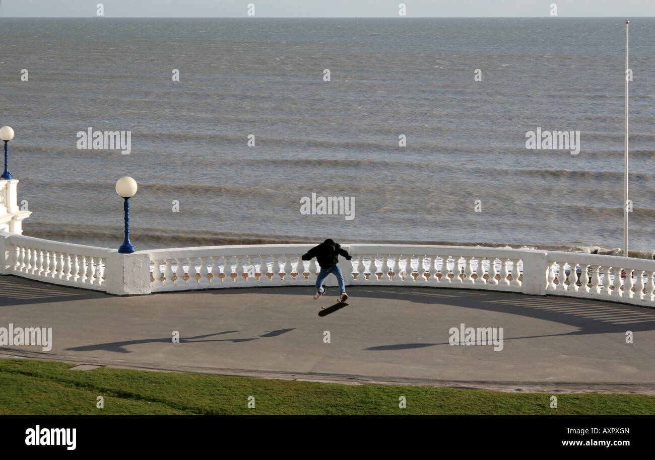 Guidatore di skateboard facendo un kickflip trucco sulla promenade a Bexhill in East Sussex, Inghilterra Foto Stock