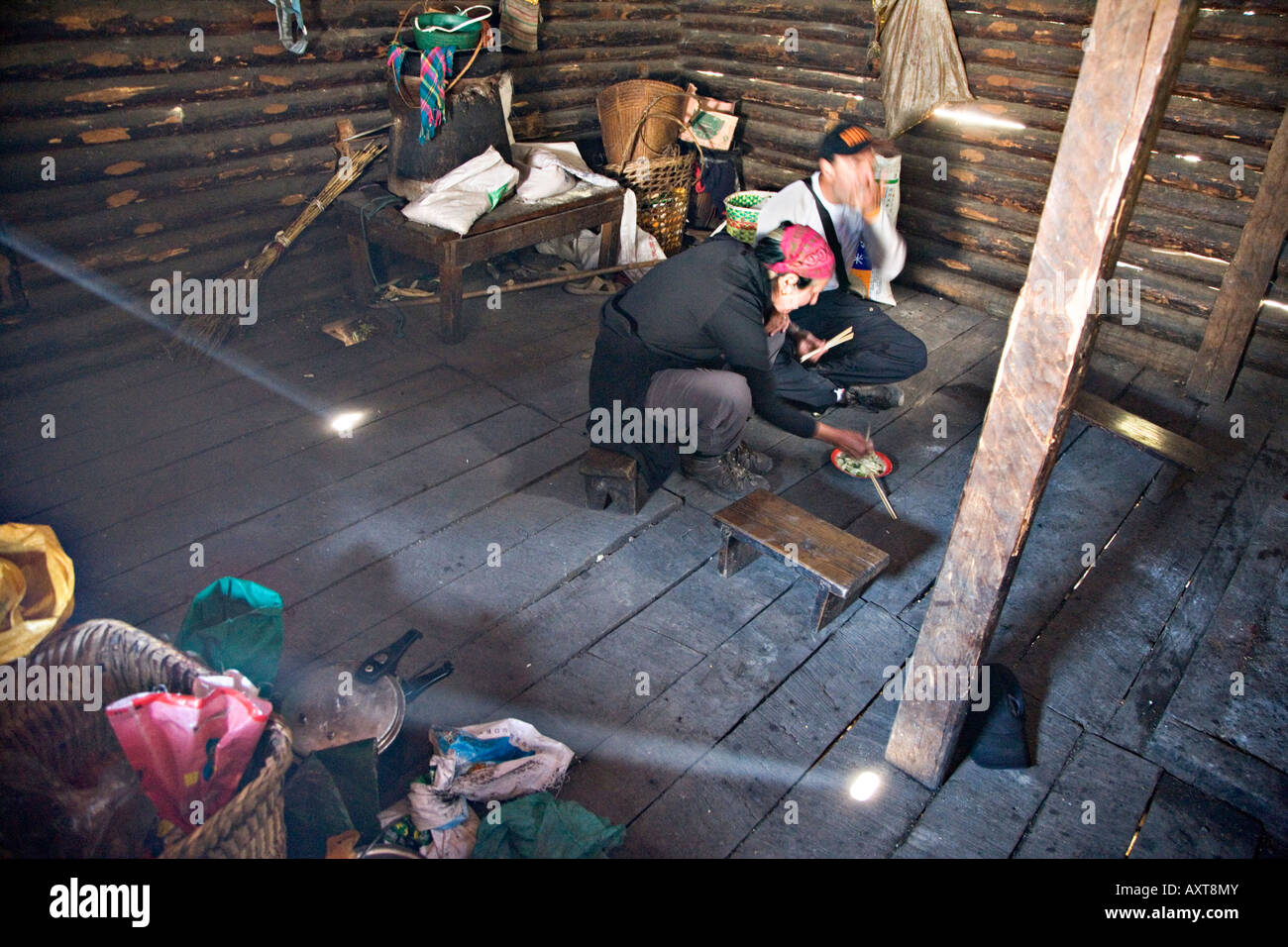 Trekkers caucasici di mangiare il pranzo in modo approssimativo log cabin, Tong Dang, Yunnan, Cina Foto Stock