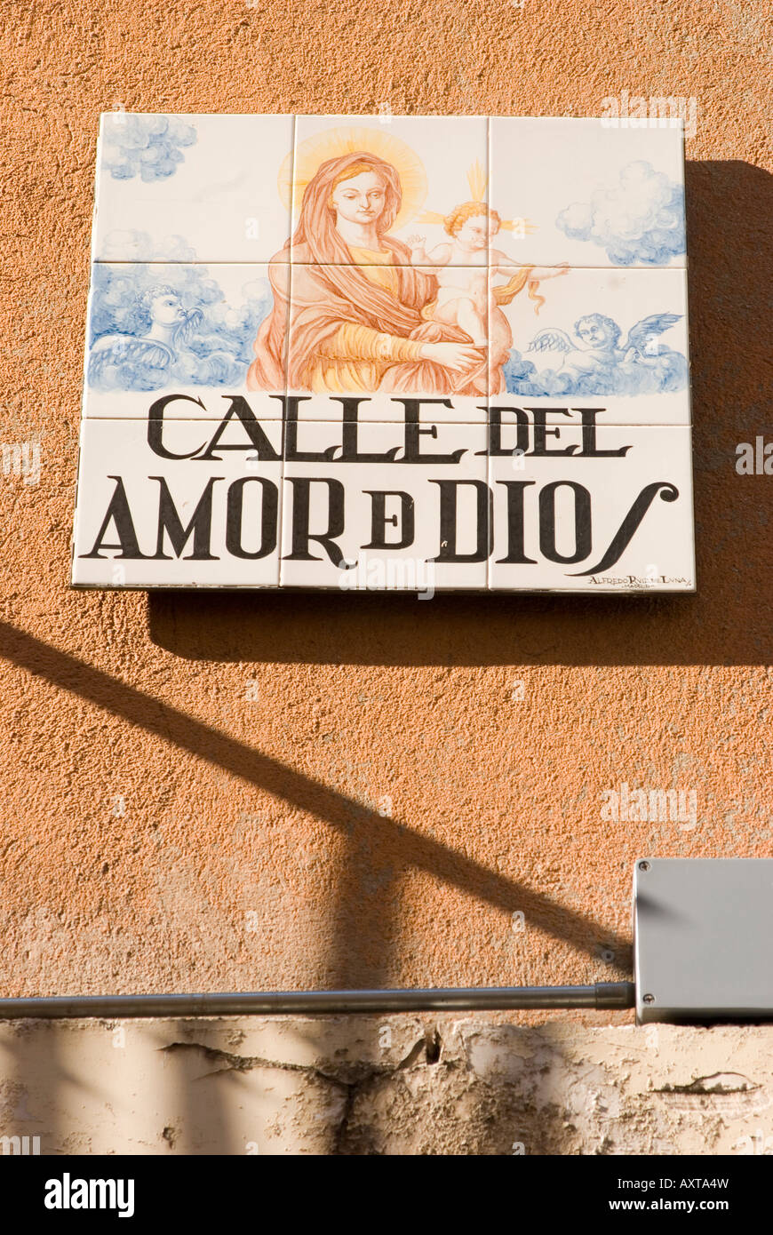 Un cartello stradale per Calle del Amor de Dios con piastrelle che mostra la Santa Maria e Gesù Bambino, Madrid, Spagna Foto Stock