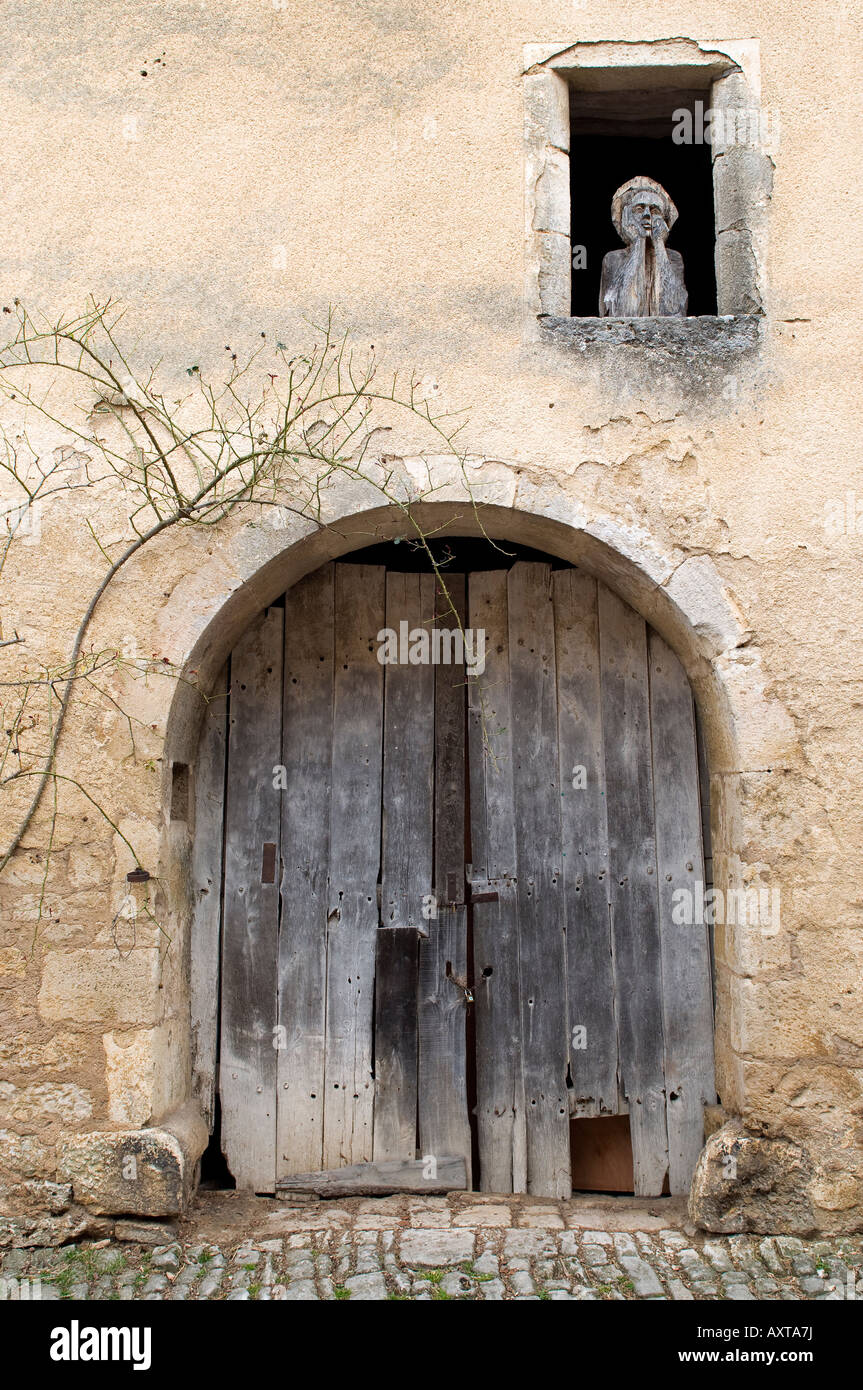 Una figura in legno guarda i passanti in una delle stradine del villaggio francese di Flavigny sur Ozerain, Borgogna Foto Stock