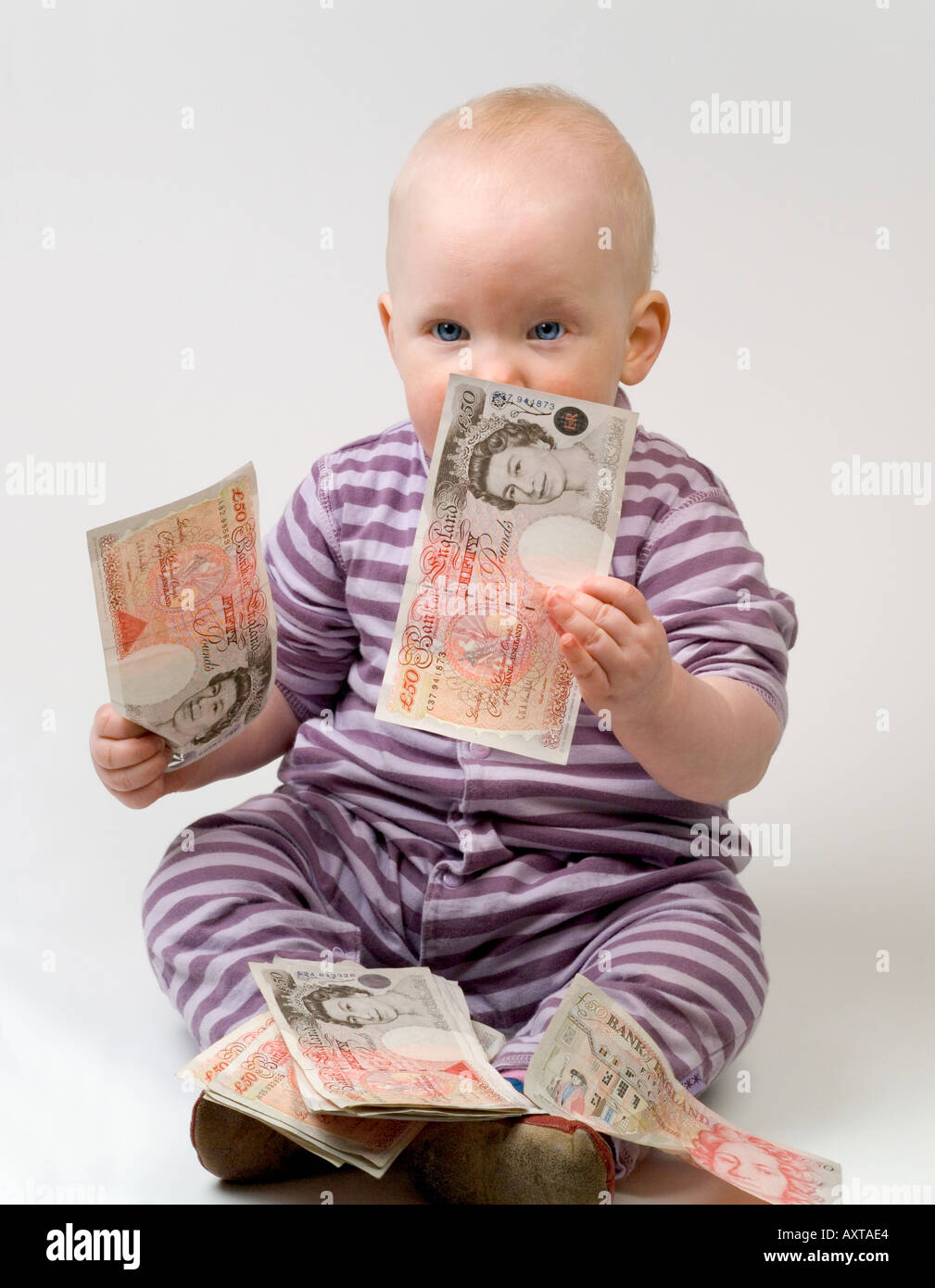 Bambino di undici mesi tenendo 50 cinquanta pound note Foto Stock