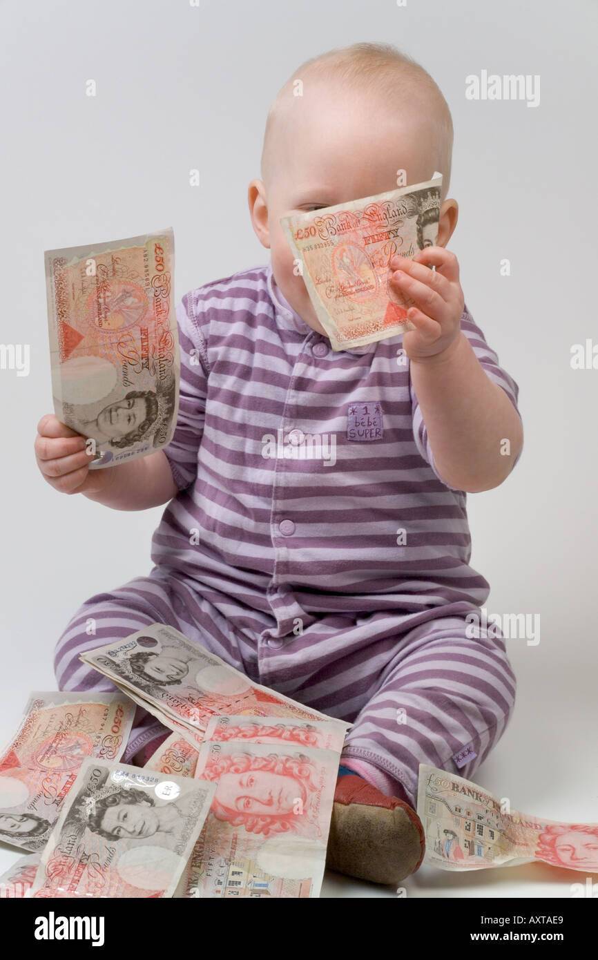 Bambino di undici mesi tenendo 50 cinquanta pound note Foto Stock