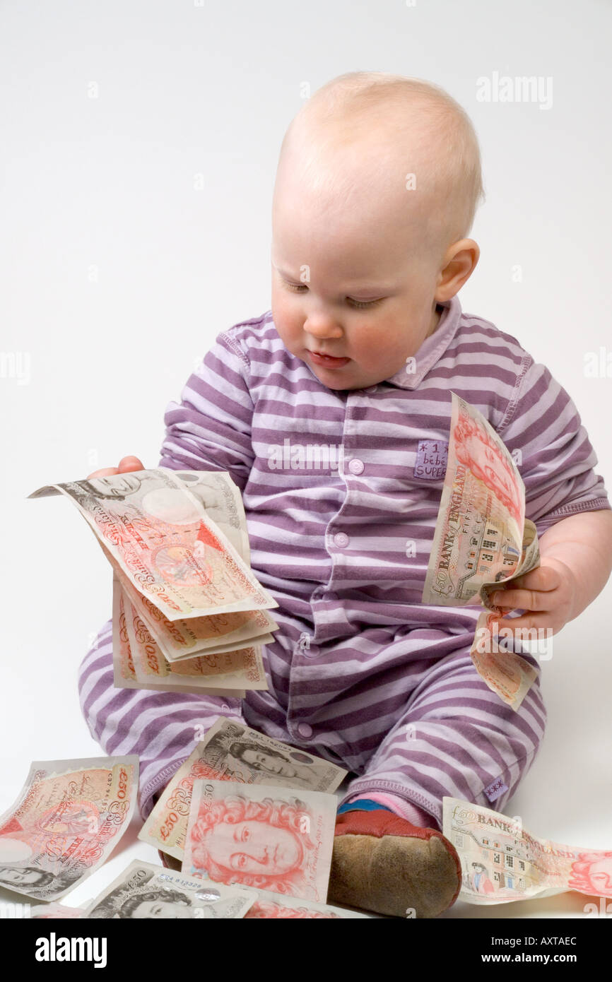 Bambino di undici mesi tenendo 50 cinquanta pound note Foto Stock