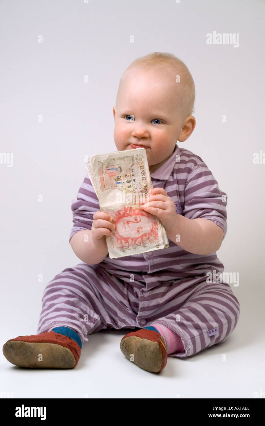 Bambino di undici mesi tenendo 50 cinquanta pound note Foto Stock