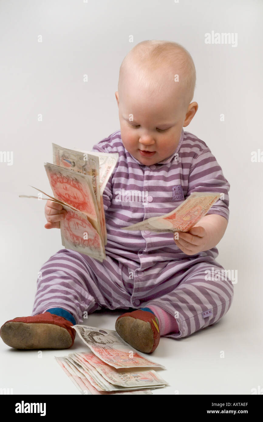 Bambino di undici mesi tenendo 50 cinquanta pound note Foto Stock