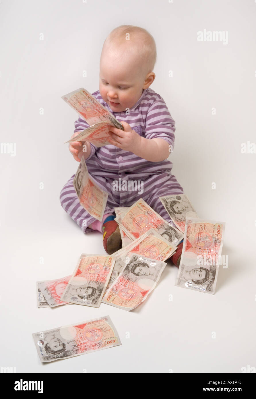 Bambino di undici mesi tenendo 50 cinquanta pound note Foto Stock
