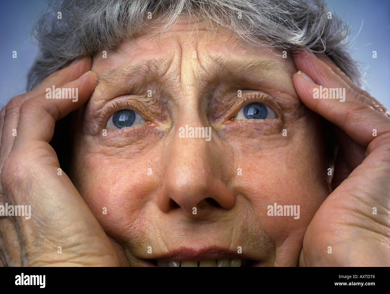Donna anziana con le mani alla testa Foto Stock