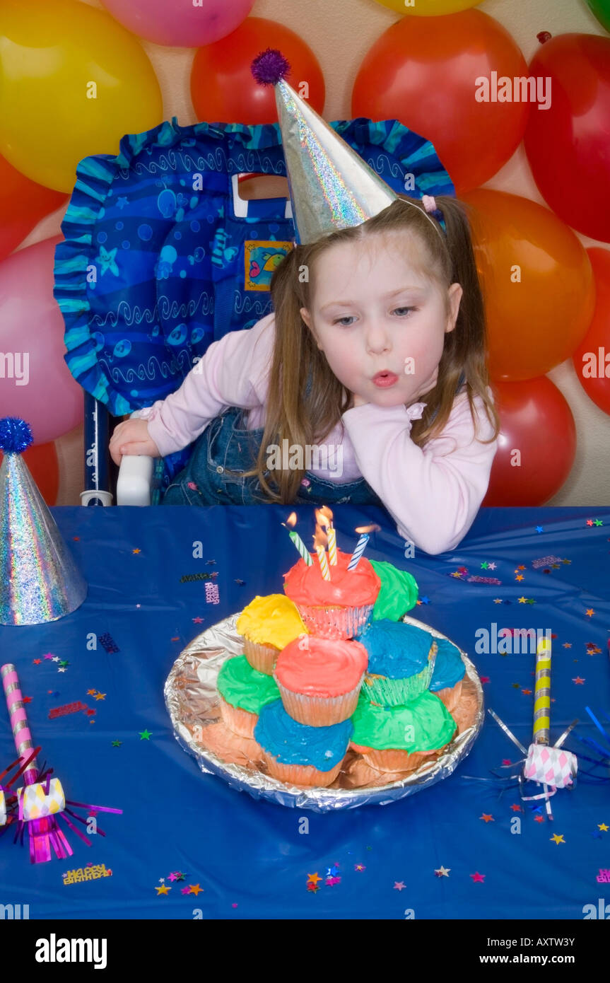 4 anno vecchia ragazza festeggia il suo compleanno con la pila di compleanno tortine di fronte a lei come ella si brucia candele Alaska Foto Stock