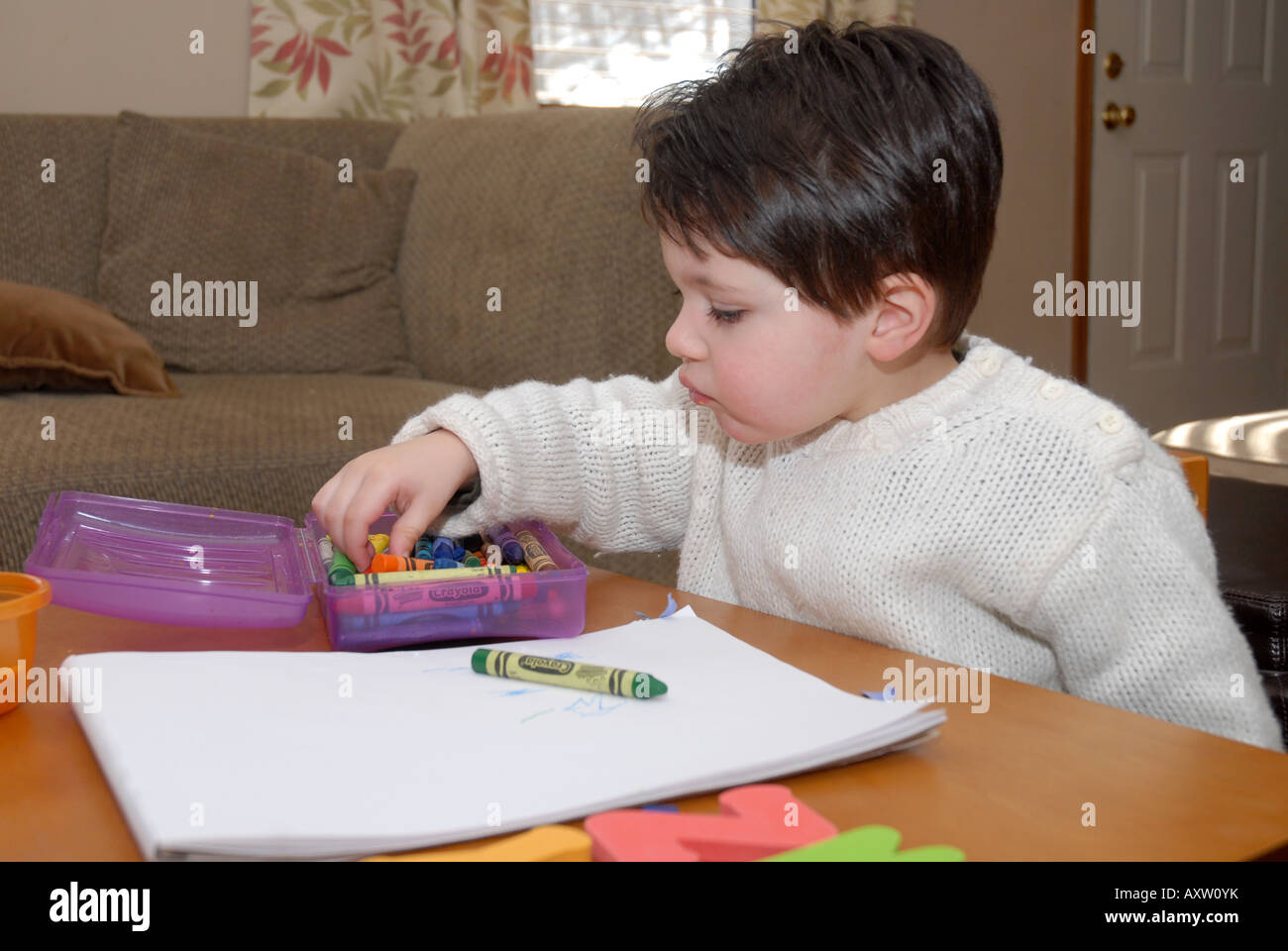 2 1/2 anno vecchio ragazzo disegna e colori nella stanza vivente Foto Stock