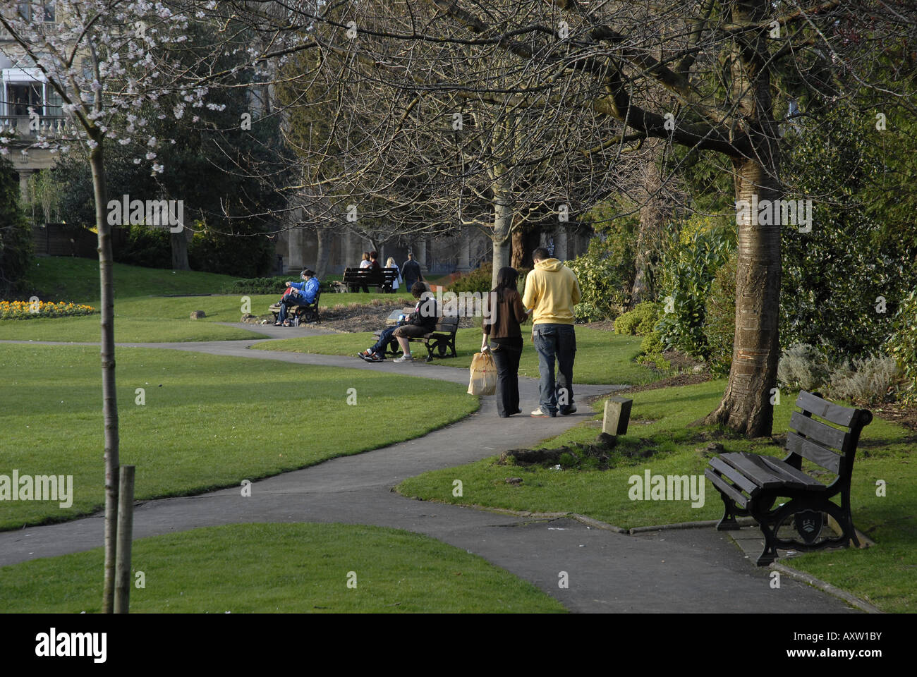 Persone e panche in un parco Foto Stock