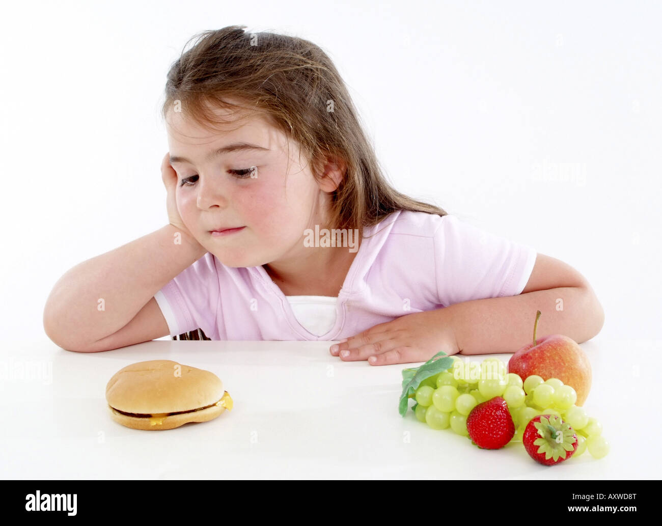 Chubby ragazza con hamburger e frutta fresca, guardando il burger Foto Stock