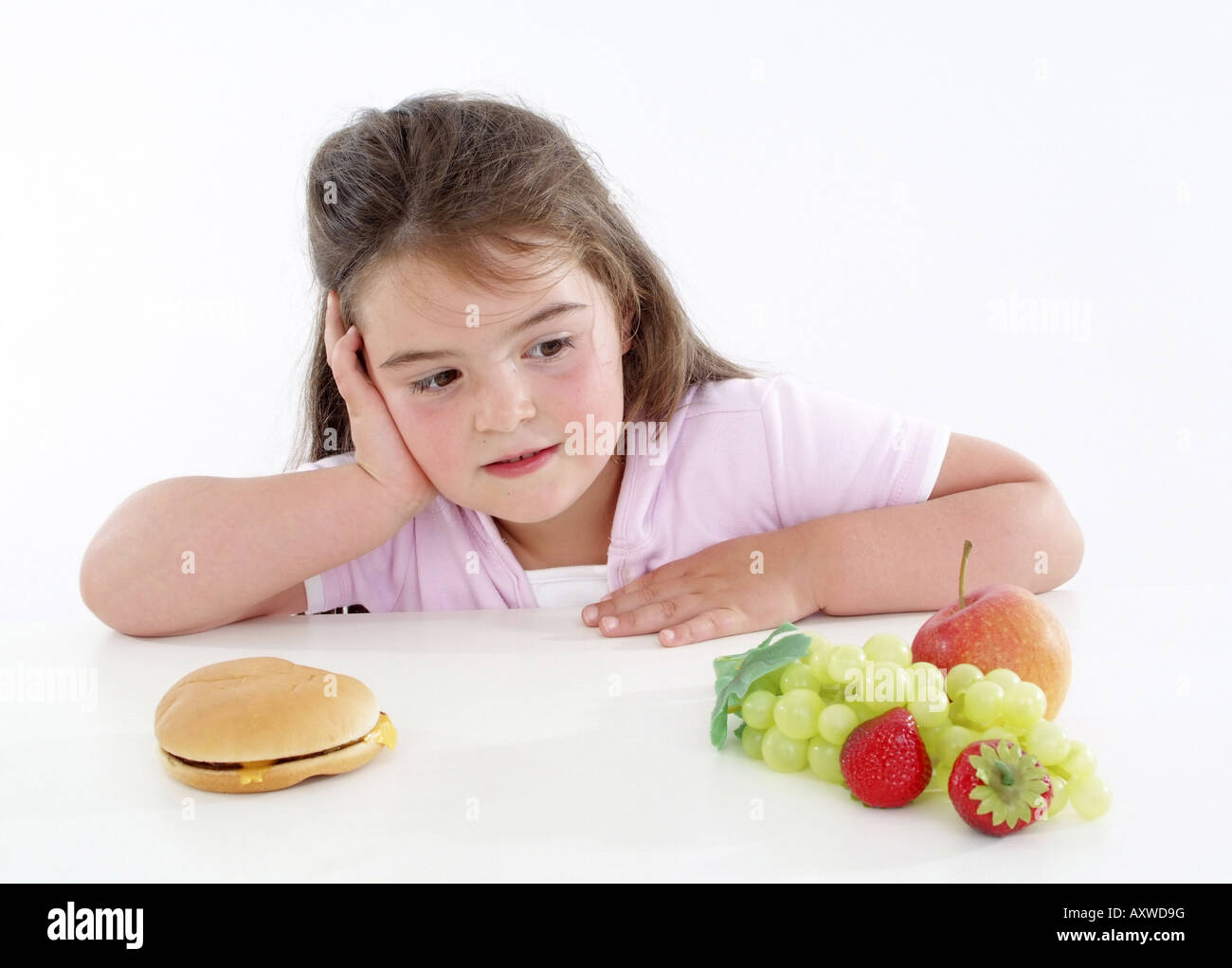 Chubby ragazza con hamburger e frutta fresca, guardando i frutti Foto Stock