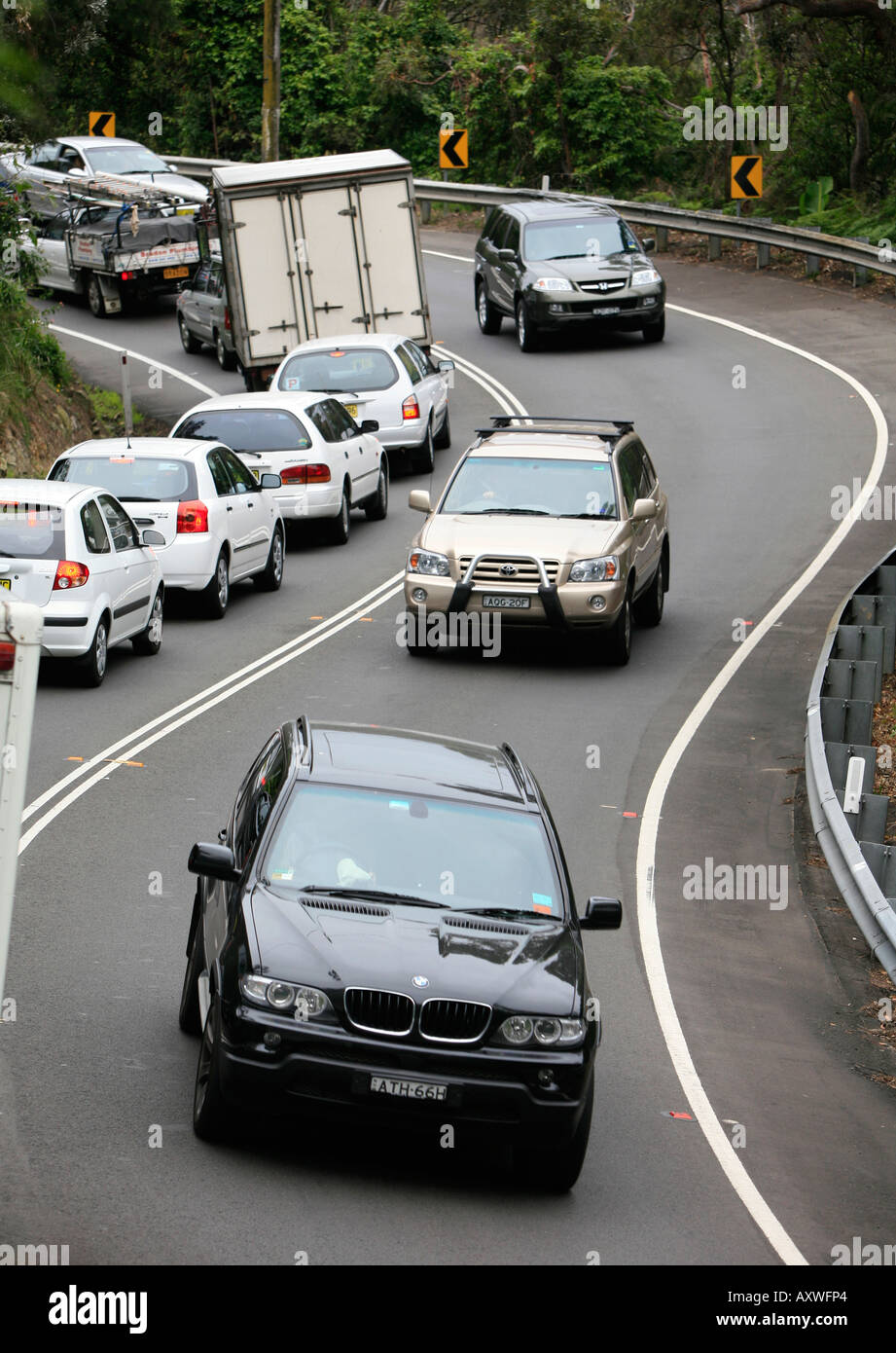 Tre i veicoli a trazione integrale in caso di traffico intenso sull'avvolgimento S bend road vicino a Avalon su Sydney s spiagge del nord Australia Foto Stock