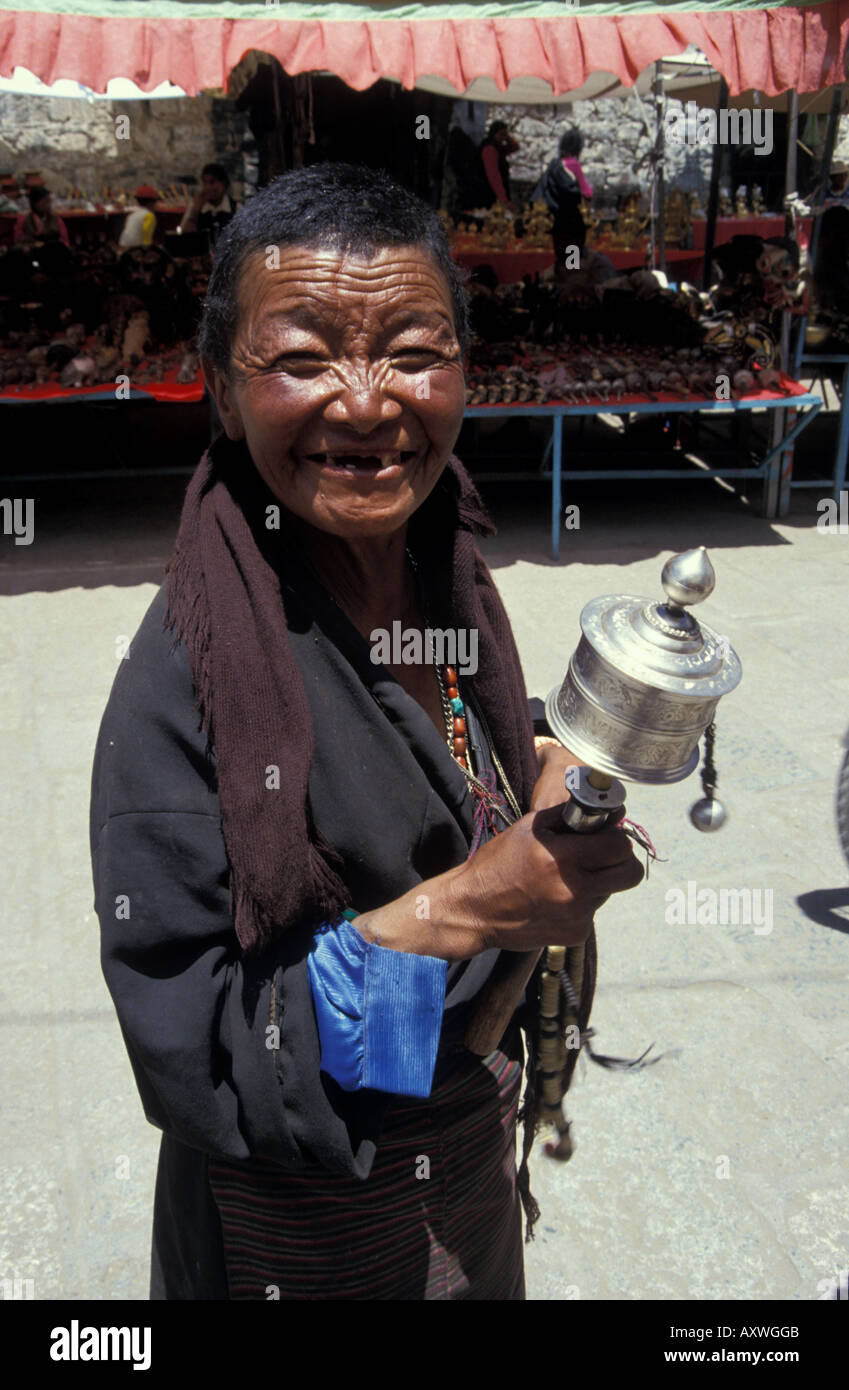 Femmina Buddista Tibetana pellegrino ruota di preghiera a piedi circuito cerimoniale di Barkhour intorno al santo tempio di Jokhang Lhasa Tibet Cina Foto Stock