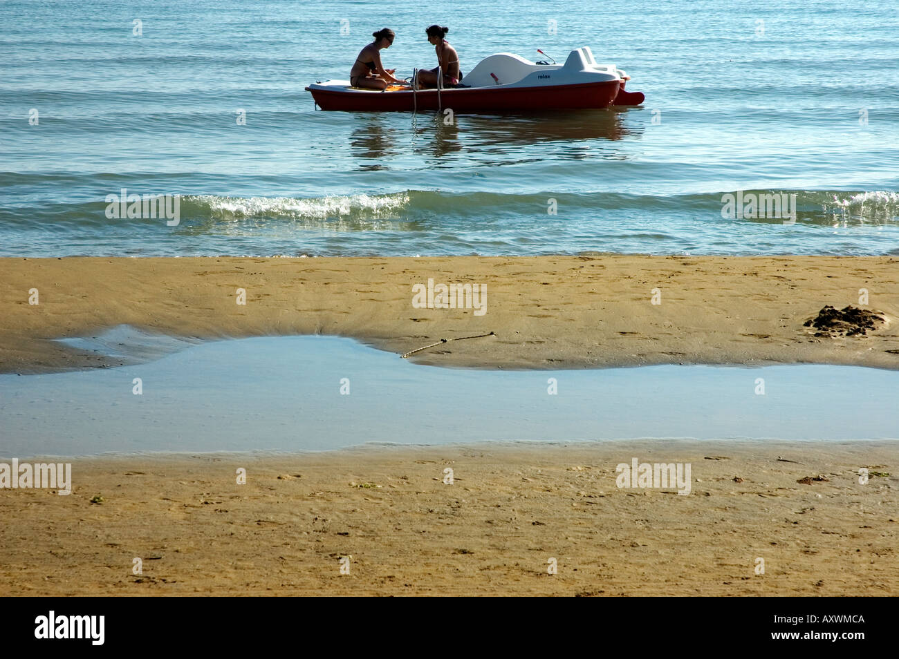 Acqua con una barca e due ragazze parlare insieme - Bibione - Regione Veneto - Italia Foto Stock