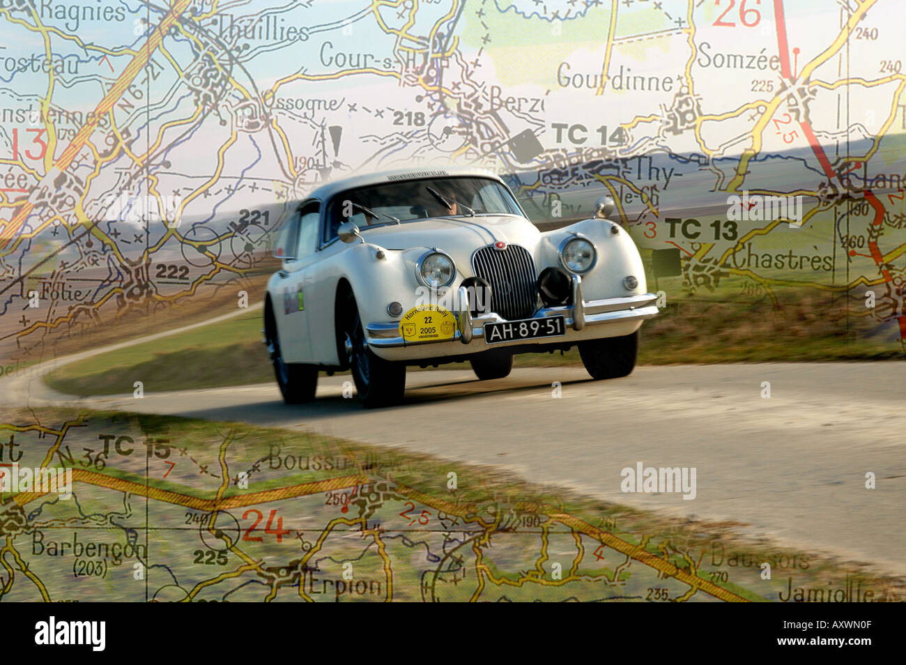 Montaggio digitale del bianco degli anni cinquanta la Jaguar XK 150 FHC sulla strada asfaltata con Michelin mappa stradale in background Foto Stock
