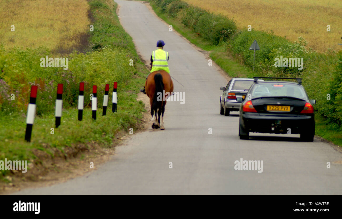 auto passando donna cavallo su strada ellingham norfolk inghilterra Foto Stock