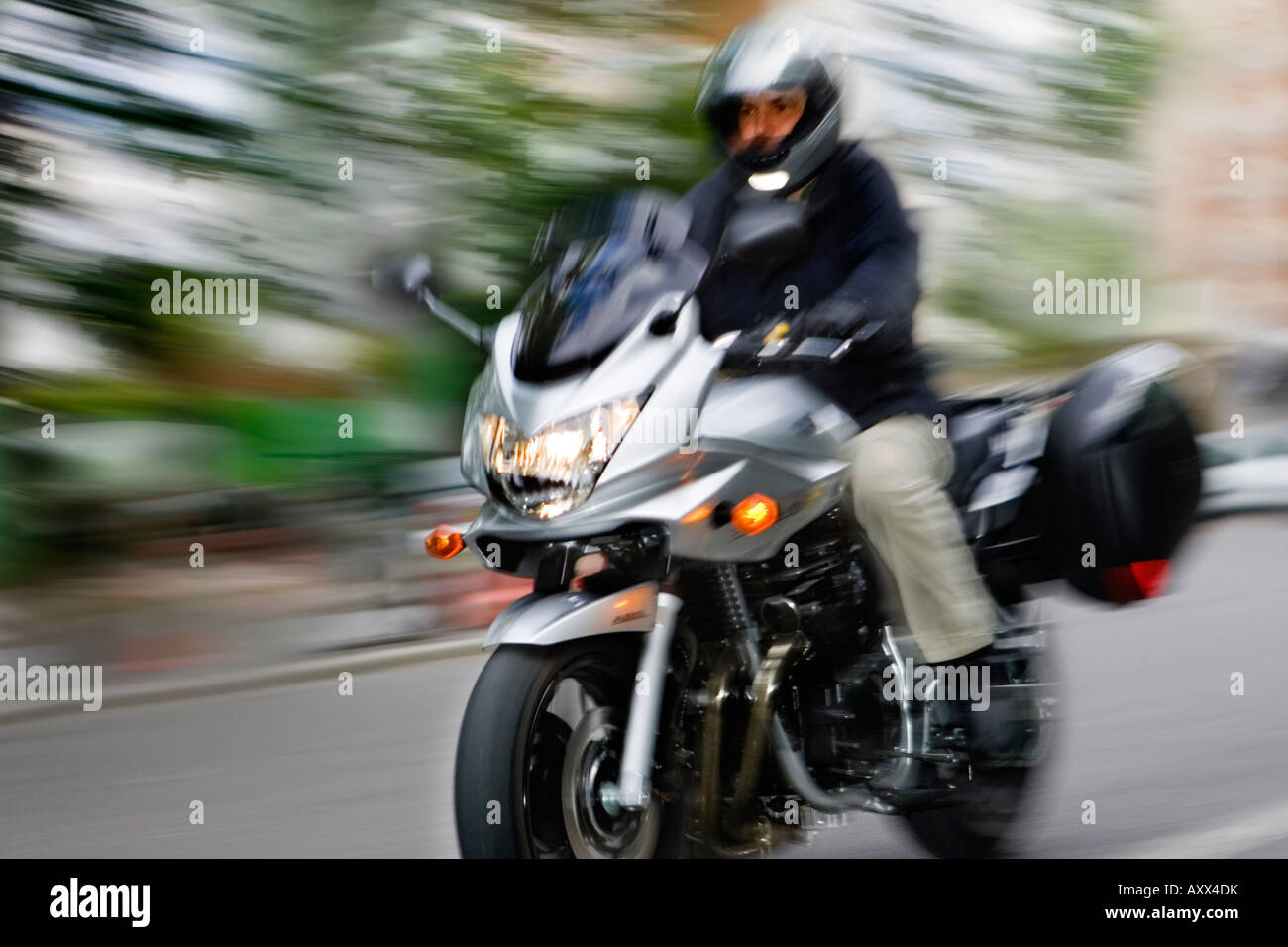 Un motociclo a cavallo attraverso il centro della città Foto Stock