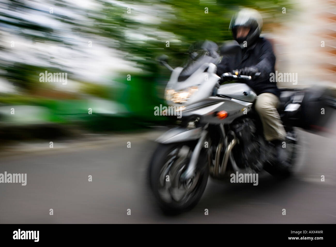 Un motociclo a cavallo attraverso il centro della città Foto Stock