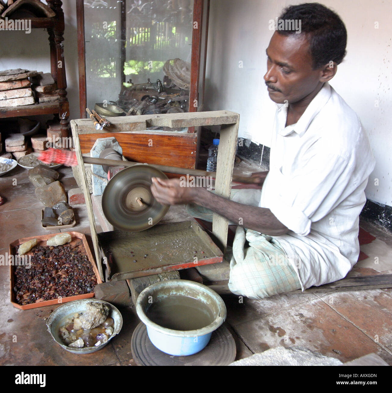 Sri Lanka gioielli - UN gioielliere che lucidano i garnet, pietre semi preziose, su un macinacaffè primitivo, Galle, Sri Lanka, Asia Foto Stock