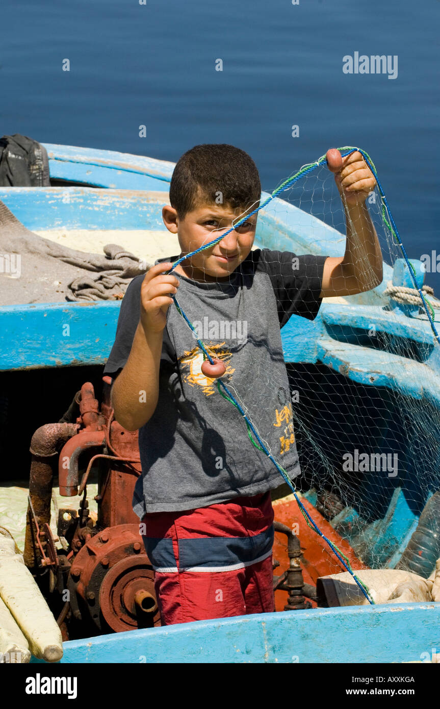 Giovane pescatore preparingthe rete da pesca su una barca Foto Stock