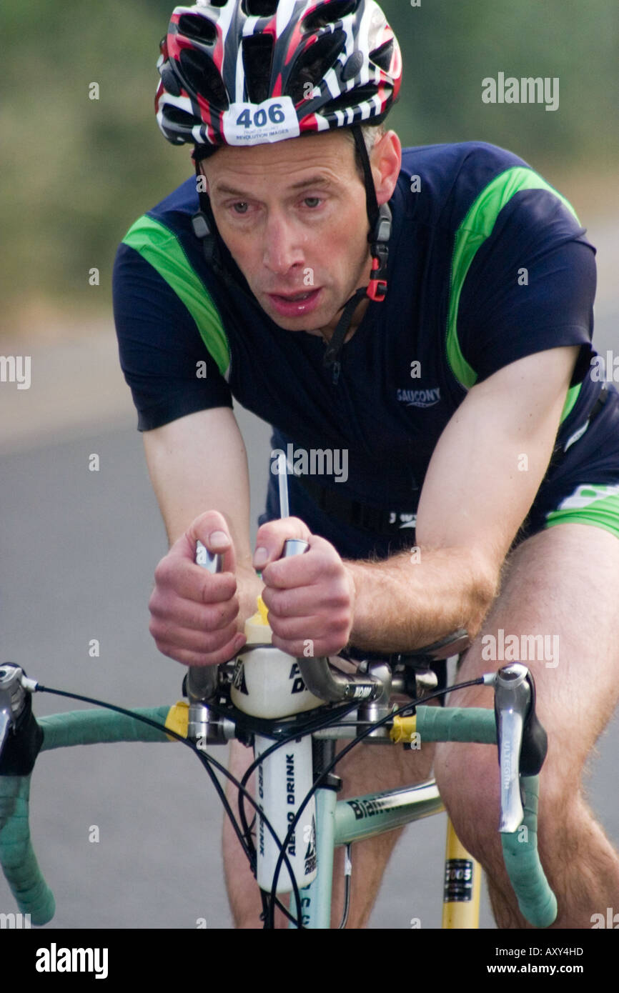 Concorrente maschile durante le escursioni in bicicletta gamba del Wakefield Triathlon 2006 mostra esaurimento sulla faccia Foto Stock