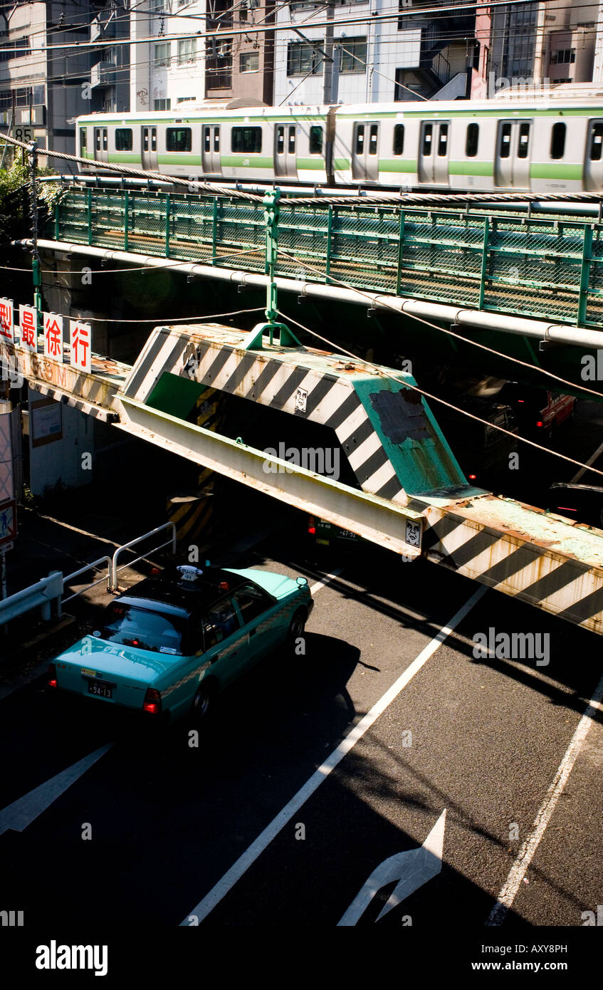 Vista di built-in alto grattacielo skyline con taxi guida sotto un ponte nel centro di Tokyo Foto Stock