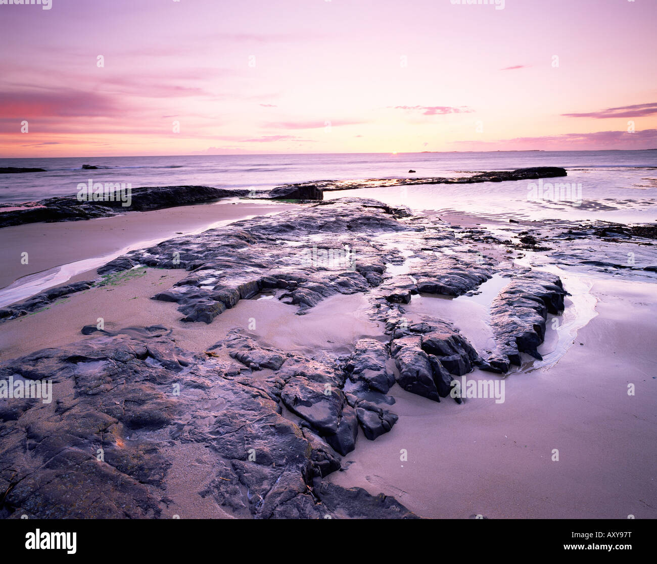Tramonto sul mare del Nord da Bamburgh beach, Bamburgh, Northumberland, England, Regno Unito, Europa Foto Stock